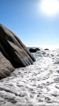 Sunny Summer Nature on a Rocky Beach with Ocean Waves Crashing against the Coast