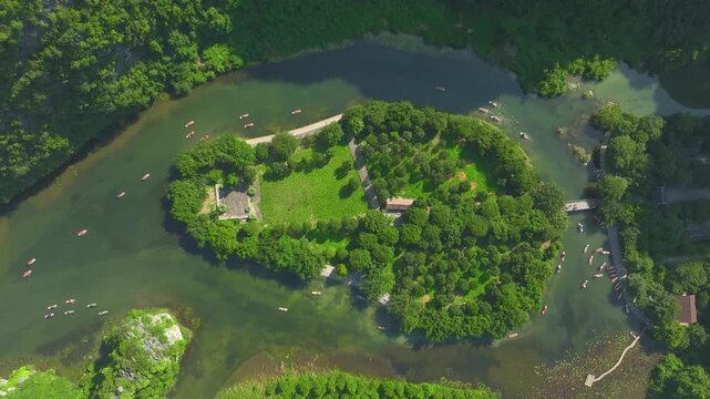top drone  view of Trang An natural landscape with limestone cliffs and waterway in Ninh Binh.
