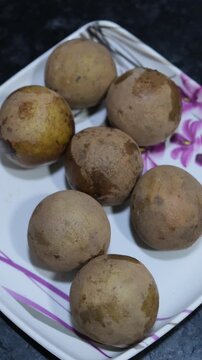Ripe Sapodilla Fruits on Plate Vertical 4K Close Up