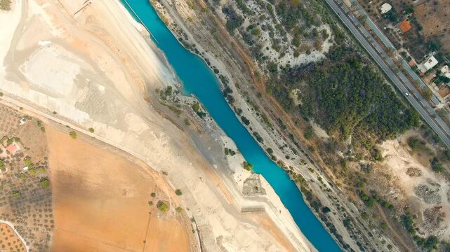 Corinth Canal, Greece. The Corinth Canal is a sluiceless shipping canal in Greece, connecting the Saronic Gulf of the Aegean and the Gulf of Corinth of the Ionian Sea. Drone footage, HEAD OVER SHOT