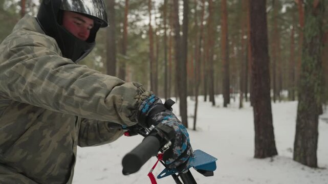 Helmeted rider adjusts atv throttle controls in pine forest closeup sequence of gloved hands on handlebars inspecting kill cord and brake lever, camouflage jacket visible, focused preride safety check