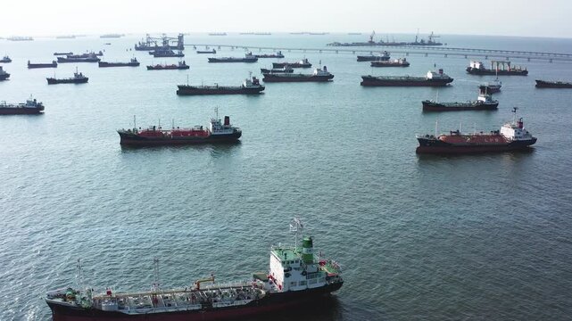 crowded tanker ships navigating Strait of Hormuz during global energy tension, dark clouds above ocean, cinematic maritime realism, Massive storm clouds loom above the ocean. Cargo ships navigate calm