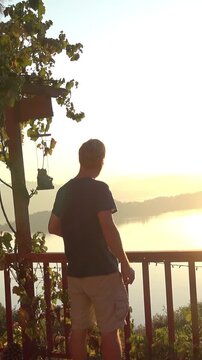 Fit athletic man walking out on a deck to enjoy the sunrise. 