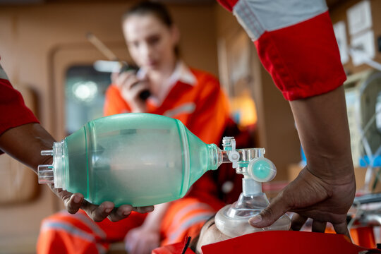 Emergency paramedic rescue ventilation airway oxygen CPR medical ambulance mask in use, careful hand seals face mask, urgent care inside ambulance, steady focus pressure drive lifesaving action