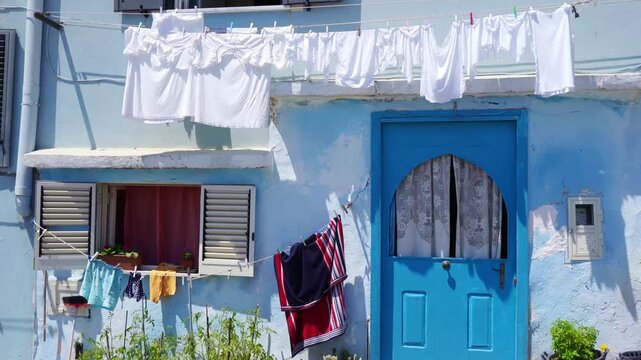Authentic Mediterranean home with blue door and laundry on a clothesline