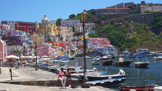 Gay couple enjoying a romantic walk along Marina Corricella in Procida, Italy