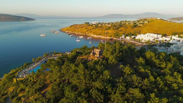 Bodrum, Turkey. Morning aerial drone view of the ancient Tiger Tower on a forested hill. This 4th century BC watchtower was built under King Mausolos as part of Halicarnassus defense system.. Aerial 