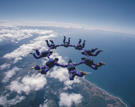 Skydivers form a human circle formation high above the ocean on a sunny day
