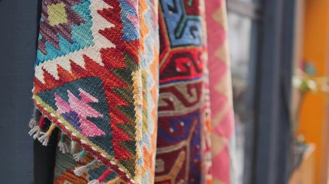 Close up of colorful turkish carpets and kilims with traditional geometric patterns hanging outside shop in Istanbul.