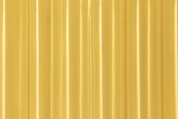 Obraz premium Abstract ribbed smooth yellow golden striped plastic pattern or texture as background