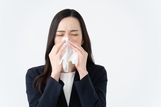 鼻水をティッシュで拭く花粉症の女性