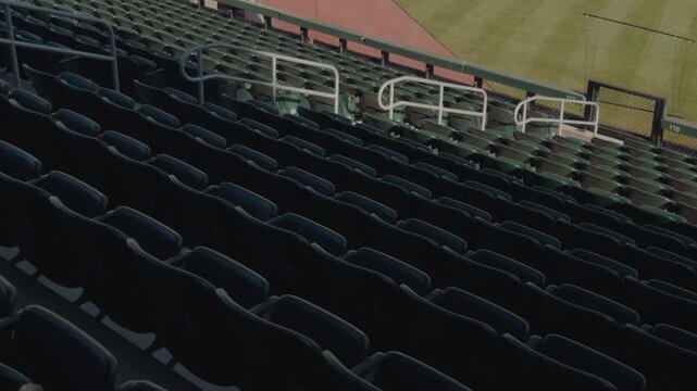Slow steady left to right pan across empty baseball stadium seating rows.