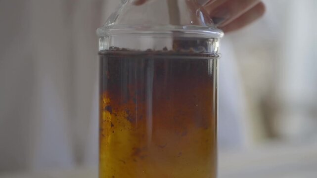 Pouring cold brew coffee into a glass container