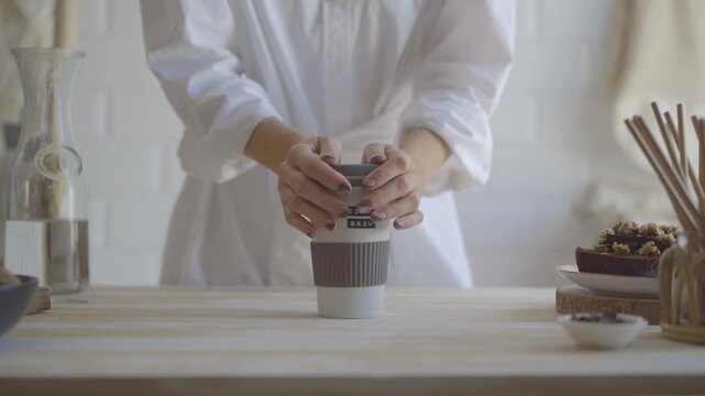 Hands reaching for a cup of iced coffee on a table
