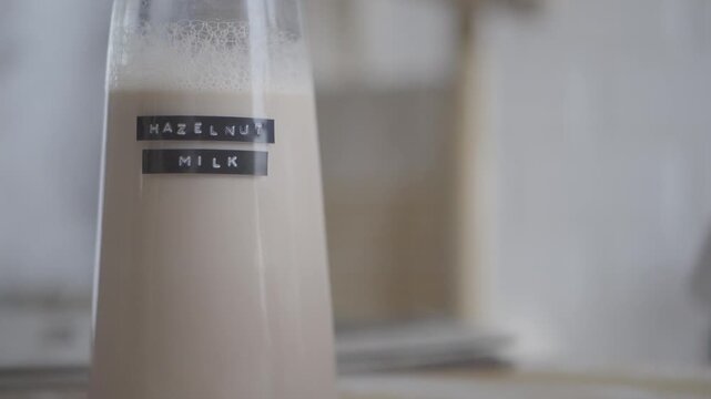 Bottles of hazelnut and oat milk on kitchen table