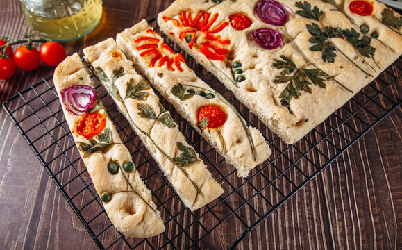 Italian focaccia bread with floral art toppings on rack