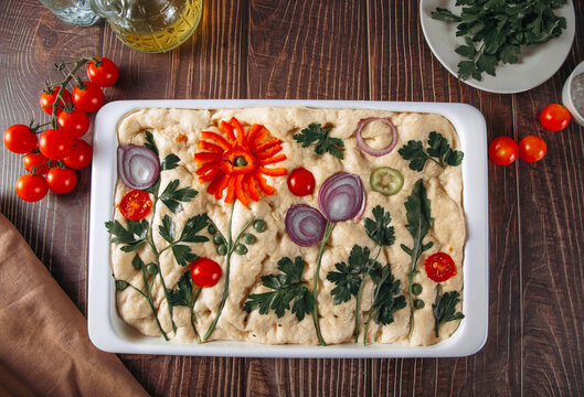 Floral focaccia bread with vegetable art ready to bake