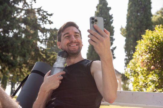 Smiling man taking selfie after outdoor yoga workout