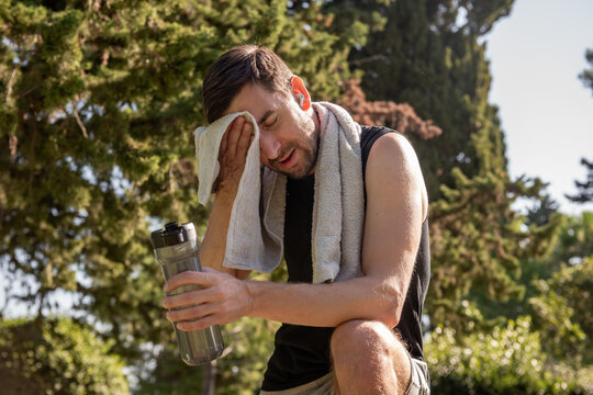 Man wiping sweat after yoga session outdoors in park