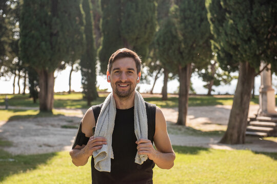 Man after outdoor yoga practice smiling with towel in park