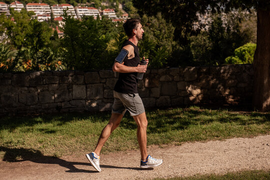 Male athlete jogging in park with visible neck birthmark