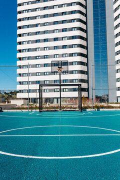 Urban street basketball court with hoop near apartment tower