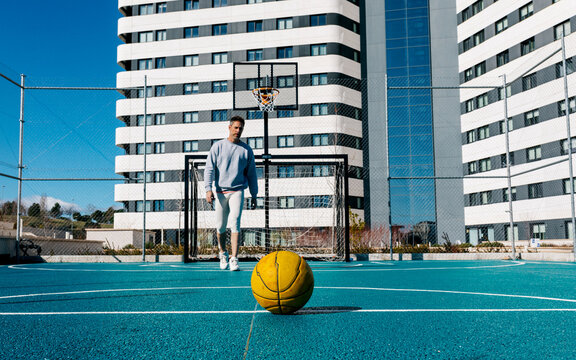 Man on street basketball court with ball in urban city