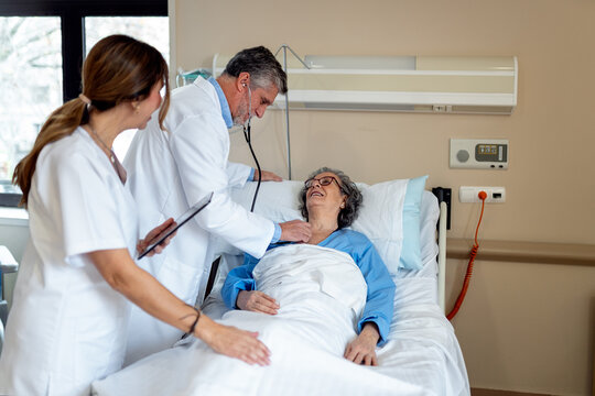 Doctors attending to a patient in a hospital room