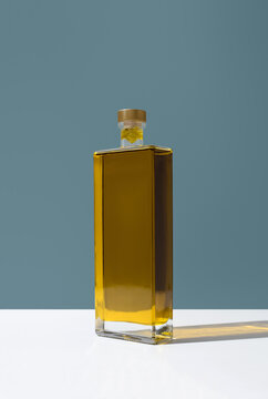 Minimalist bottle of olive oil on blue background still life