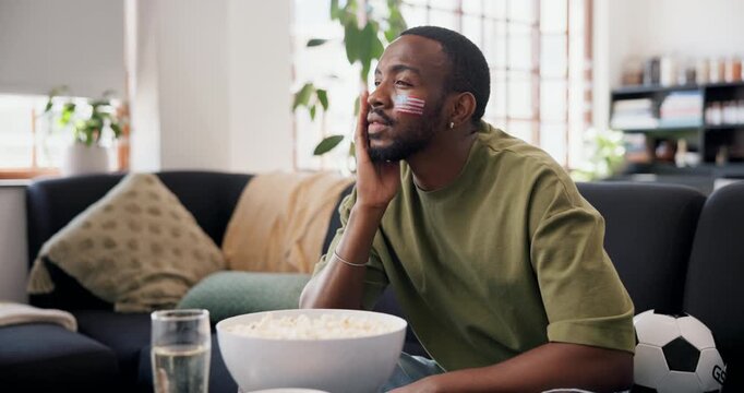 Frustrated, sad or black man watching tv in lounge, sports competition or upset for soccer game results. Live streaming, football fan or disappointed for tournament loss in home, flag or team failure