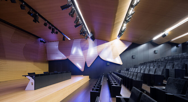 Modern art exhibition hall with seating and stage