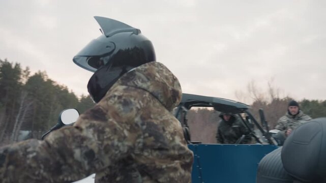 Preparing for snowy winter adventure. Offroad rider equips himself for icy forest expedition adventures. ATV operator meticulously plans and gears up for challenging winter woodland journey