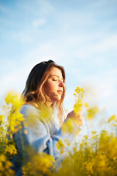 Serene woman enjoying spring in flower field