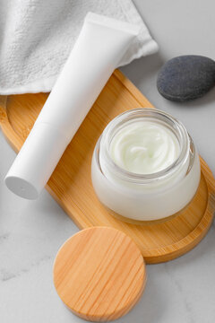 Minimal cosmetic skincare jar and tube on wooden tray