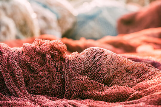Fishnet pile in harbor with red fishing net close-up