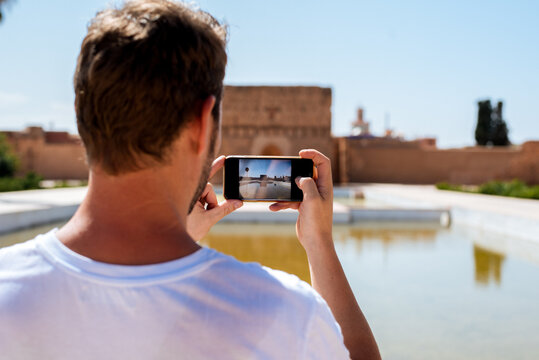 Man using smartphone at El Badi Palace, Morocco travel