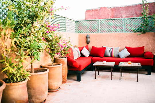 Moroccan riad rooftop lounge with vibrant red sofa decor