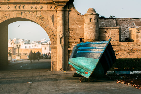Fishing boats at dawn by old castle wall in Marrakech