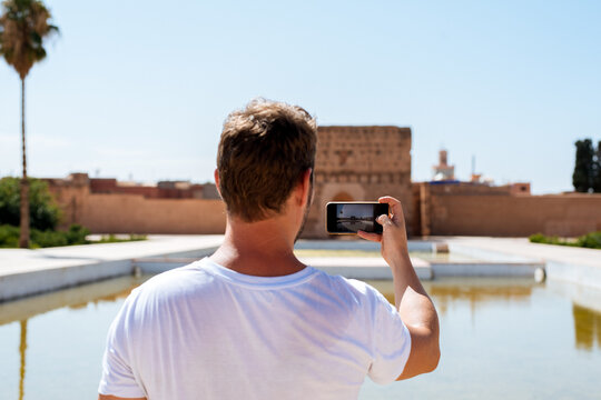 Man using smartphone at El Badi Palace, Morocco travel