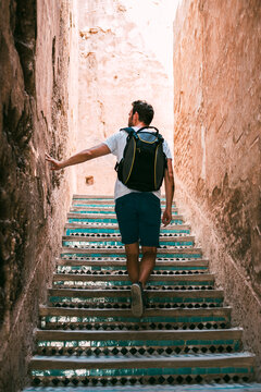 Tourist climbing tiled stairs in Marrakesh old medina alley