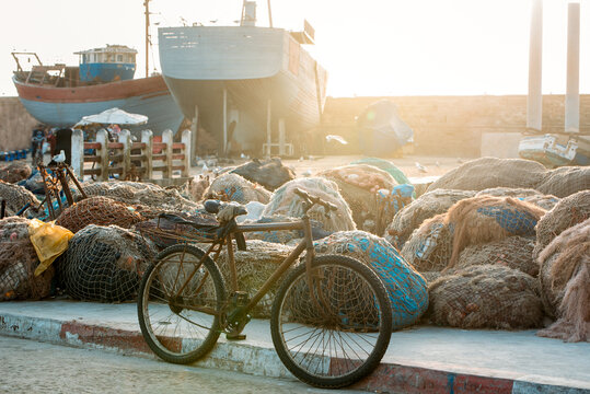 Fishing boat anchored near fishnet pile and bicycle