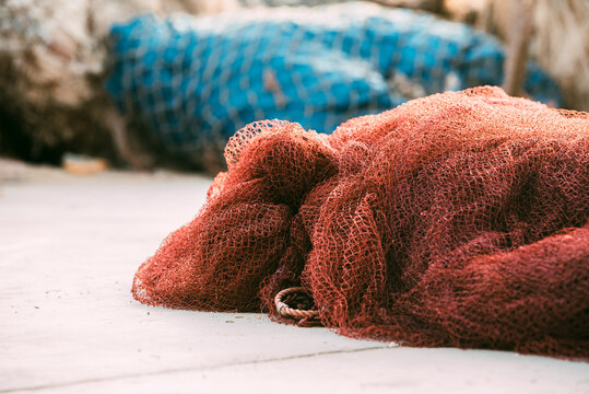 Fishnet pile on harbor dock with fishing gear closeup