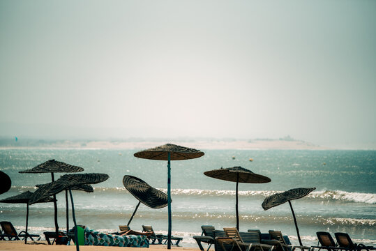 Relaxing scene at Essaouira beach with straw parasols