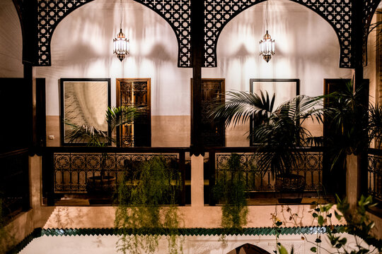 Moroccan riad courtyard with arches, lanterns and plants