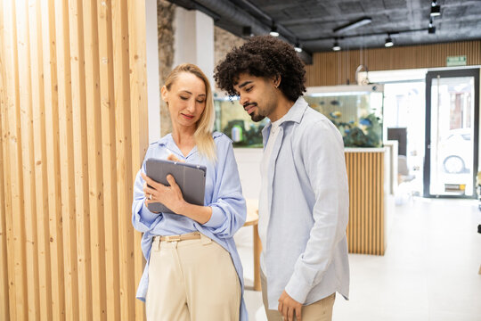 Latin man and female coworker reviewing a tablet in office