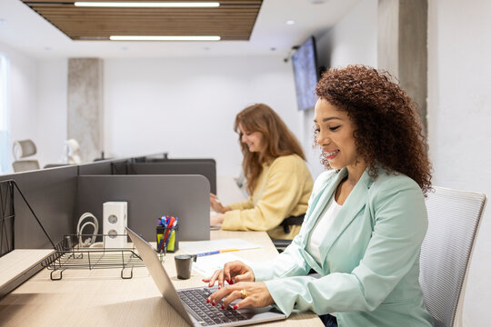 Modern coworking team working on laptops in open office