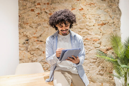 Latin man using tablet in bright modern office space