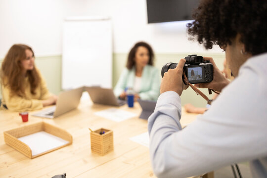 Photographer capturing coworking team meeting in office