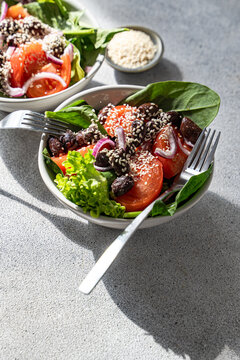 Spinach salad with sesame, tomato, olives and onion bowl