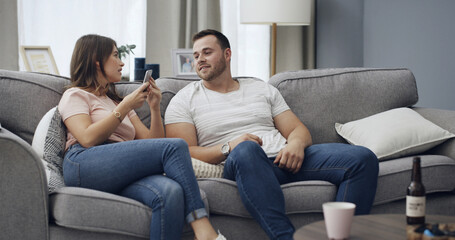 Obraz premium Couple, secret and confession with phone for cheating affair, toxic relationship or privacy in home. Man, woman or spying with mobile smartphone for separation, trust issue or conflict in house